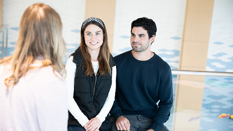 Indoor photo of a couple consulting with doctor